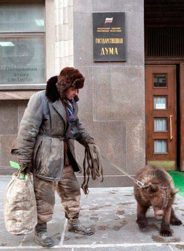 Мужчина с медведем прогуливается у здания Государственной...