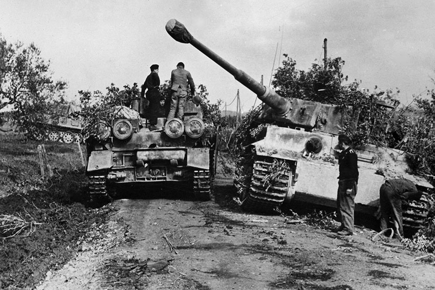 Немецкая САУ Sturmpanzer-IV едет мимо танка Pz.-Kpfw.-VI-Ausf. H1-«Тигр»...