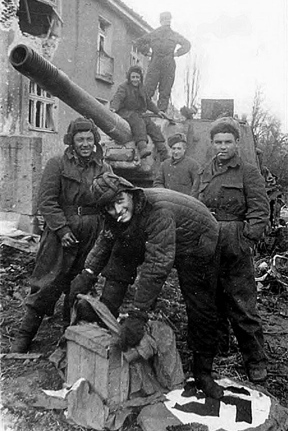 Механик-водитель ИСУ-152 вытирает сапоги фашистским флагом,...