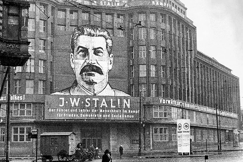 Плакат с изображением Сталина на здании ЦК Единой партии...