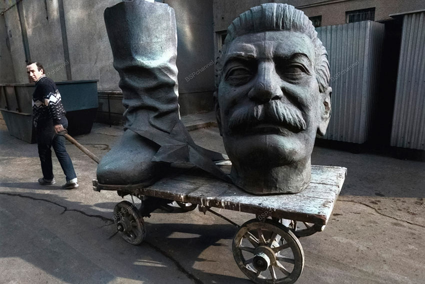 Мужчина тащит части статуи Сталина после того, как было...