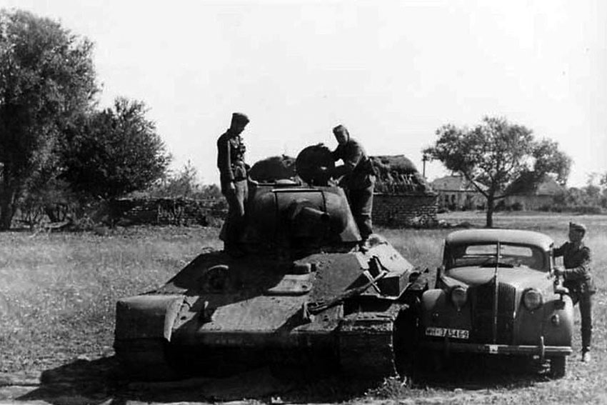 Брошенный танк Т-34 осматривают немецкие солдаты, 1941 год.